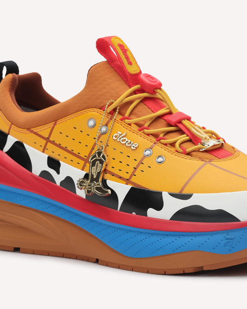 Colorful sneaker with cow print and decorative elements on a white background
