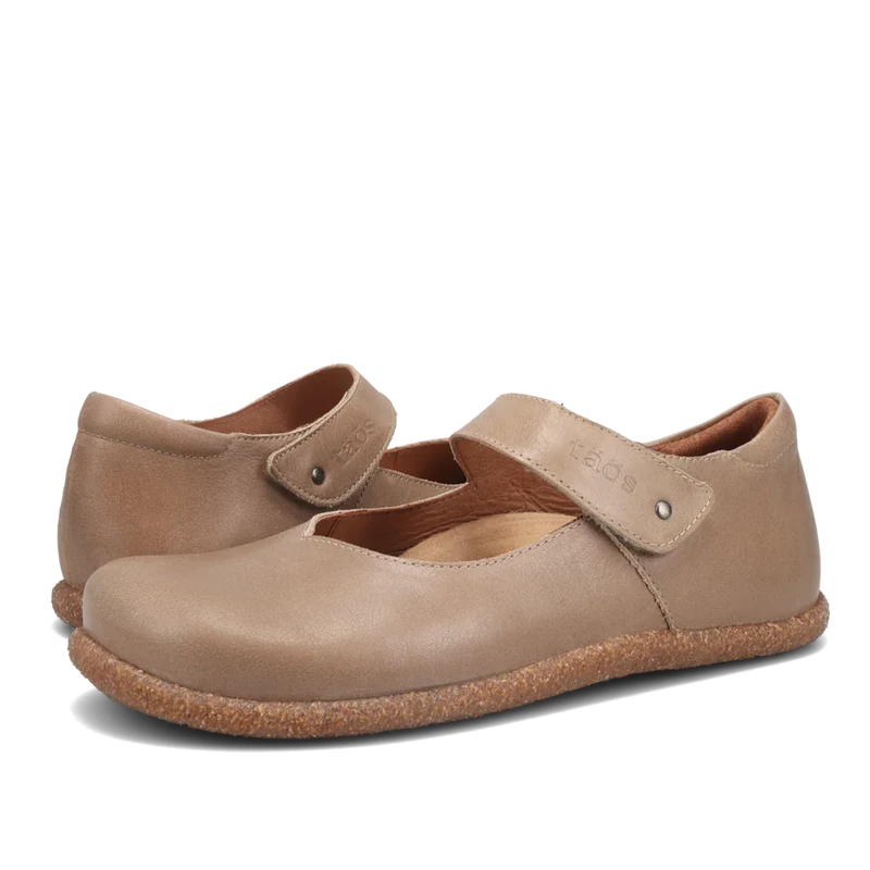 Pair of beige shoes with a strap on a white background