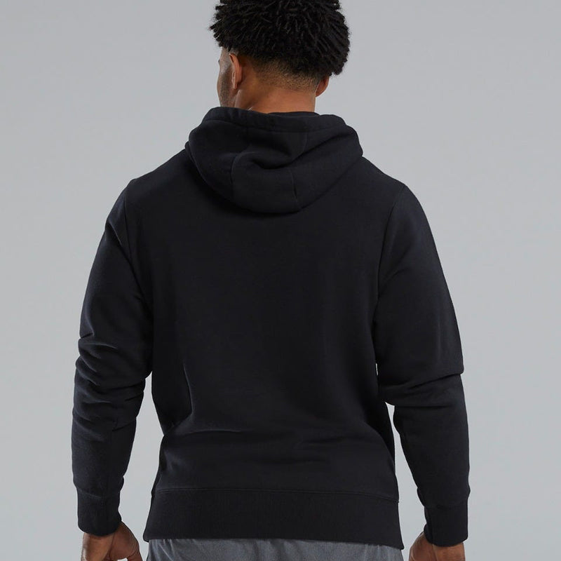 Person wearing a TYR black hoodie on a gray background